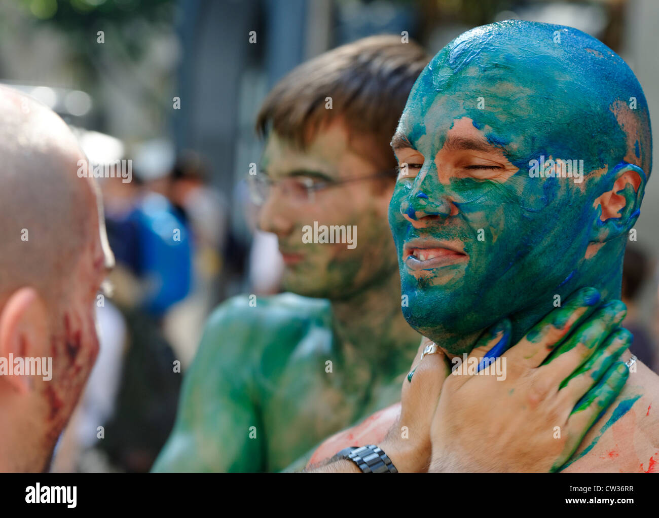 Painting a man blue - revelers at the Zurich Street Parade, a techno and trance festival. Stock Photo