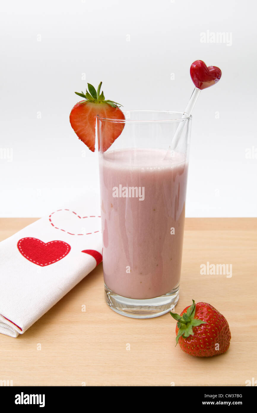 Strawberry milkshake made with fresh strawberries, with strawberry slice and strawberry on the side Stock Photo