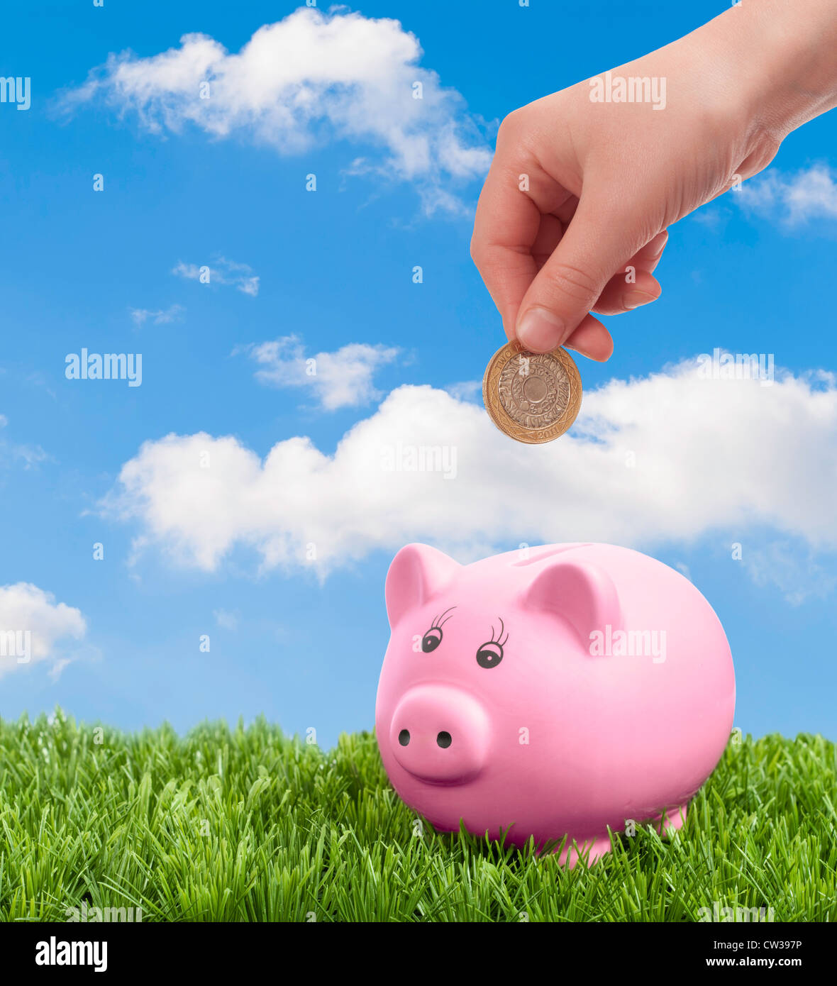 Hand depositing coin into piggy bank Stock Photo - Alamy