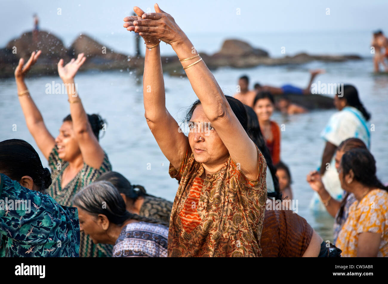 Indian women praying at the sea. Kanyakumari. Cape Comorin. India Stock Photo