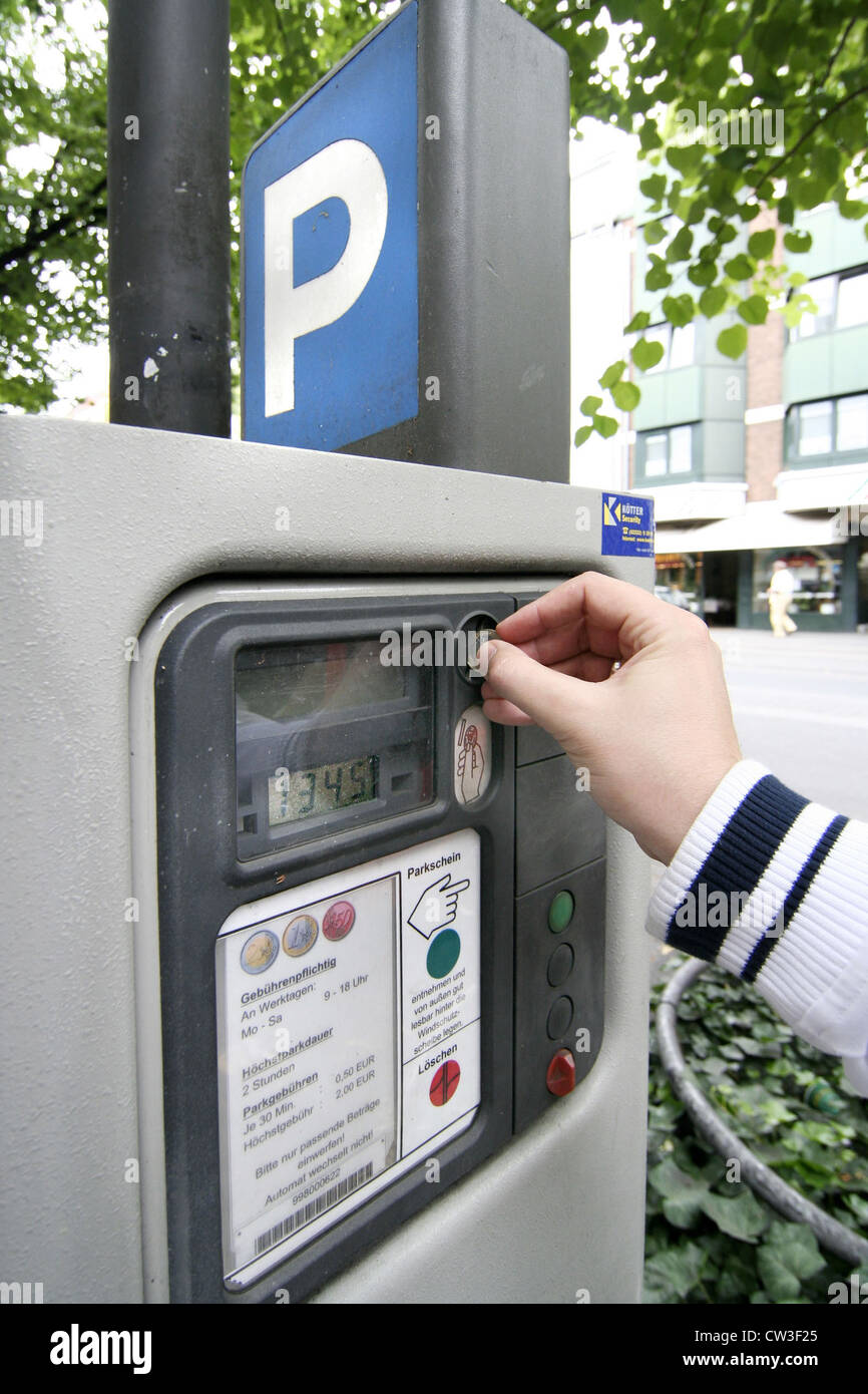 Man putting coins into a parking meters Stock Photo Alamy