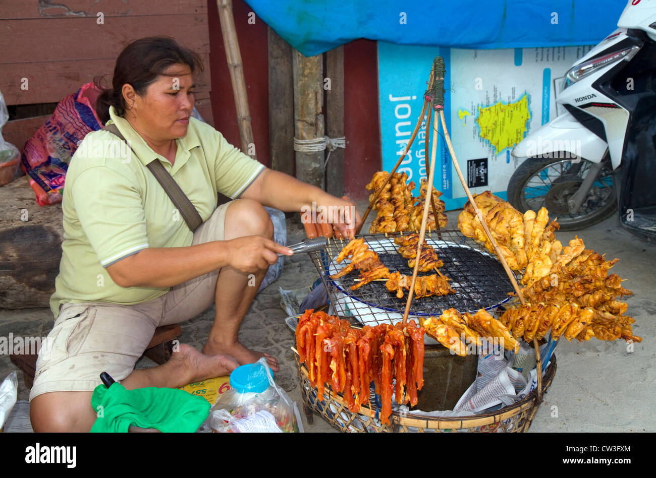 Food vendor grilling meat over a charcoal fire at Chaweng beach on the island of Ko Samui, Thailand. Stock Photo