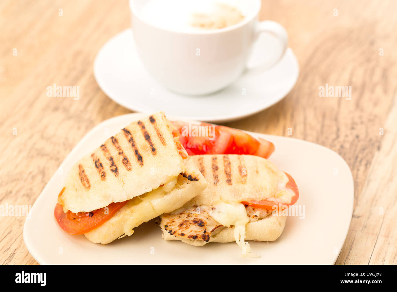 Toasted Chicken, tomato and mozzarella Panini sandwich that has been cut in half and placed on a plate Stock Photo