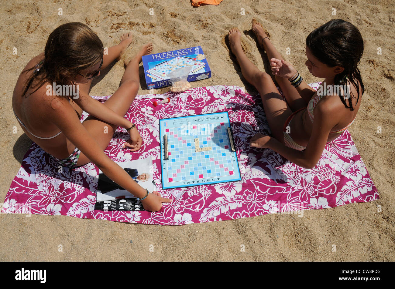 YOUNG GIRLS ON THE BEACH PLAYING INTELECT SANT FELIU DE GUIXOLS GIRONA CATALONIA SPAIN Stock Photo