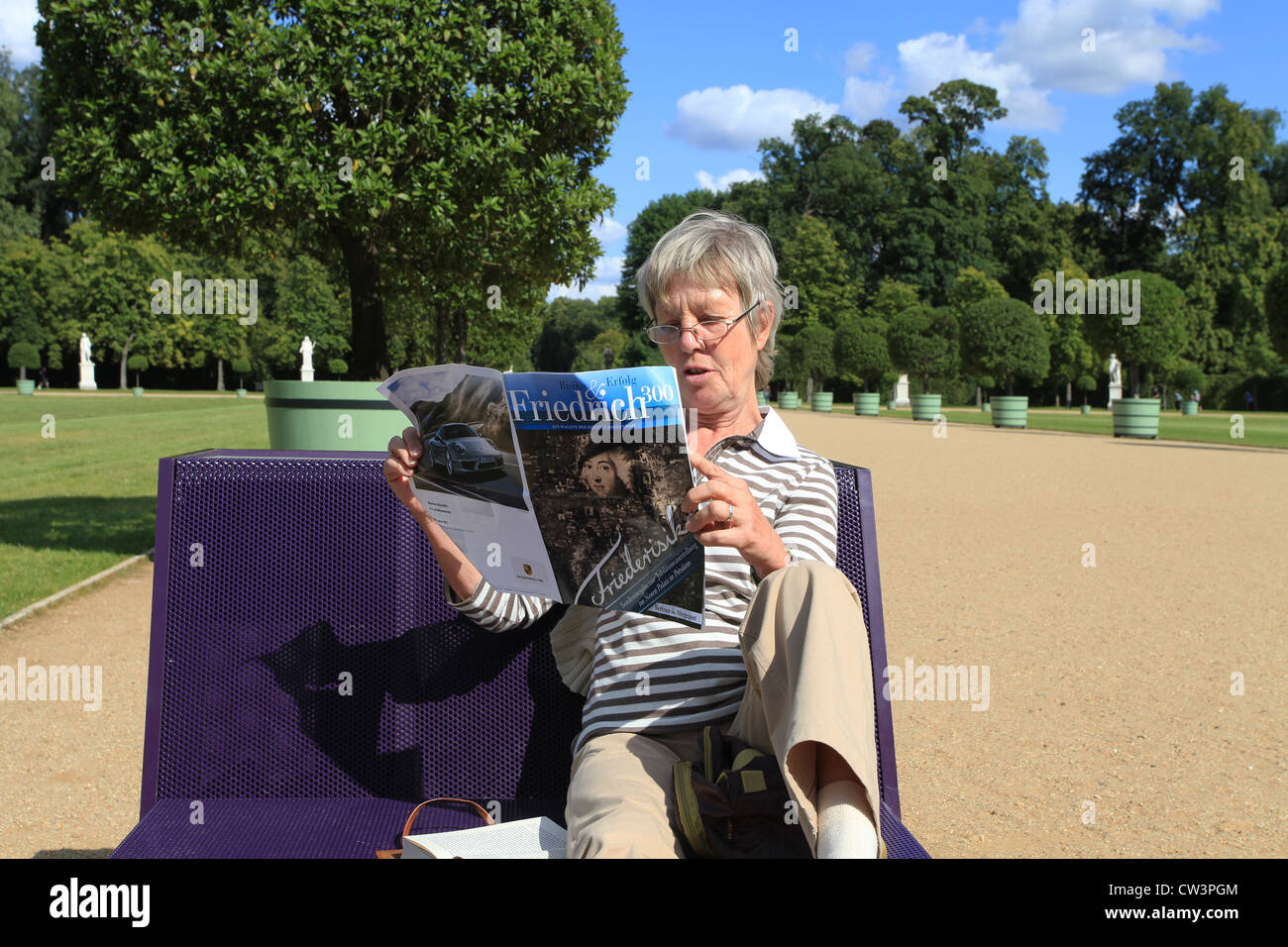 A woman reading a brochure about Frederick the Great during her visit of the exhibition 'Friederisiko'. Sanssouci Park, Potsdam. Stock Photo