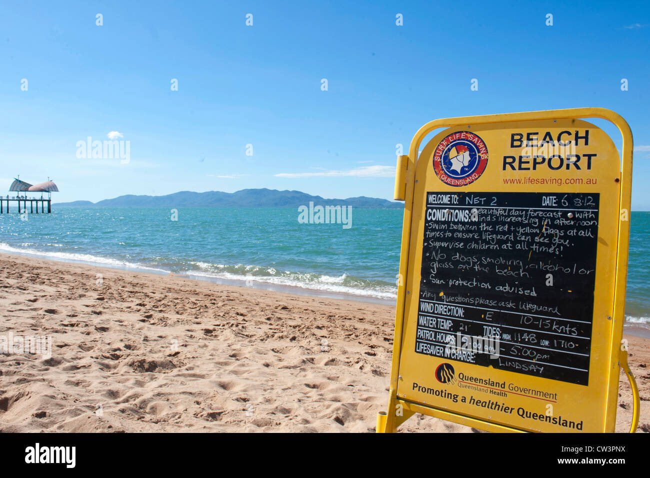 Beach report on sun,water, weather on board at The Strand, Townsville\'s  main beach, with fishing pier at the distance Stock Photo - Alamy
