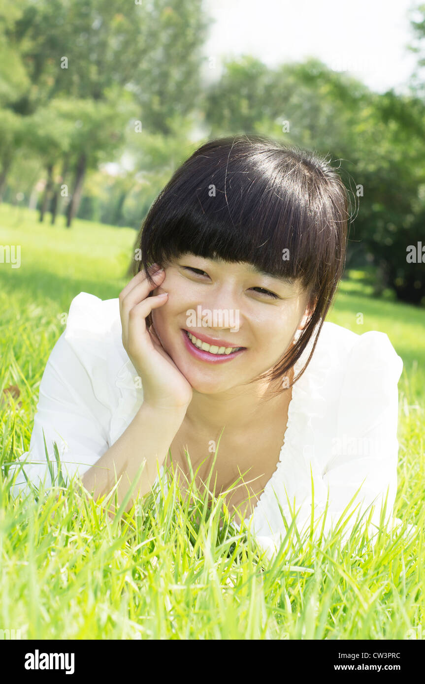 Woman lying on the grass smiling Stock Photo - Alamy