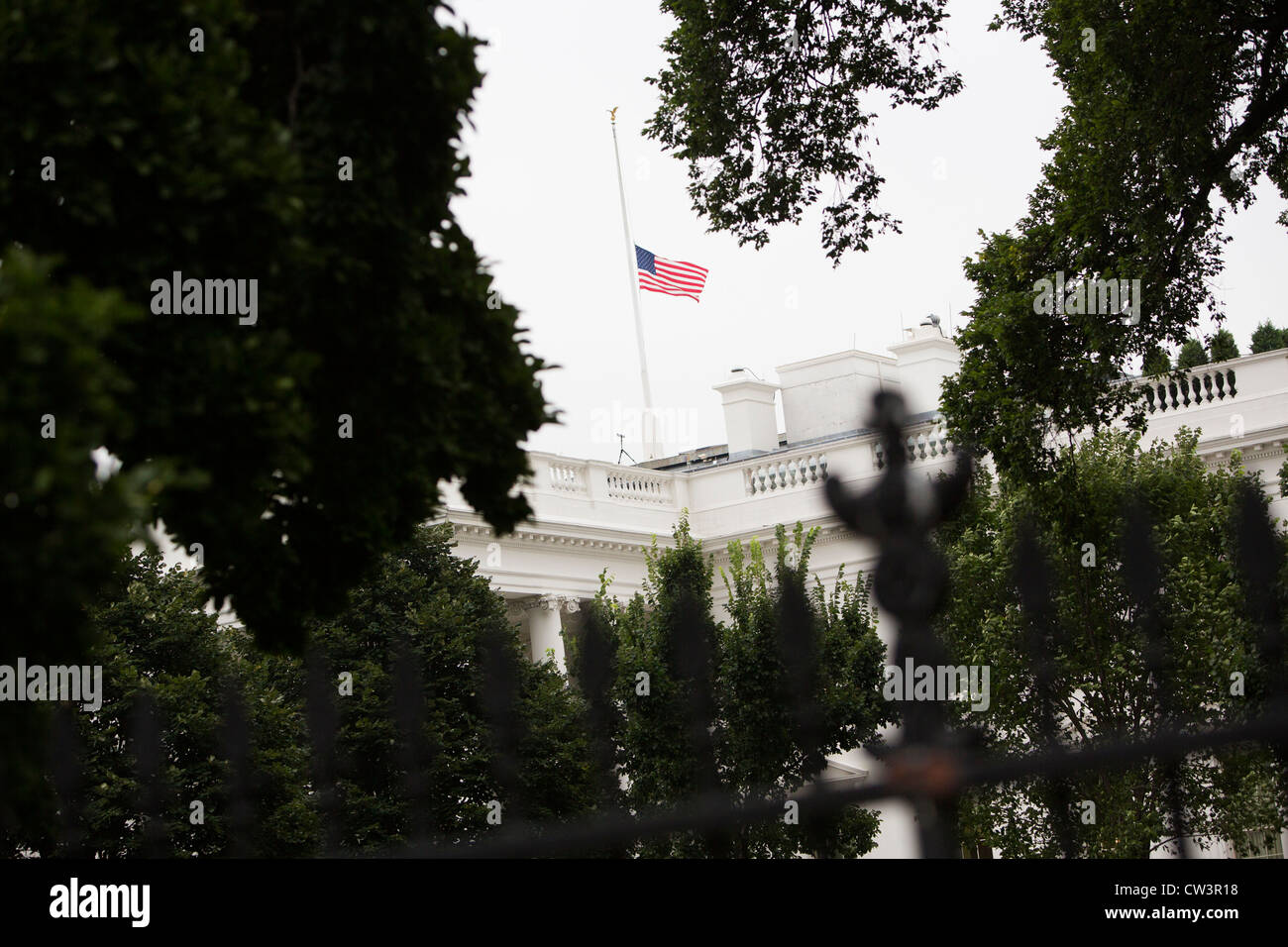 The White House with its flag lowered to half mast. Stock Photo