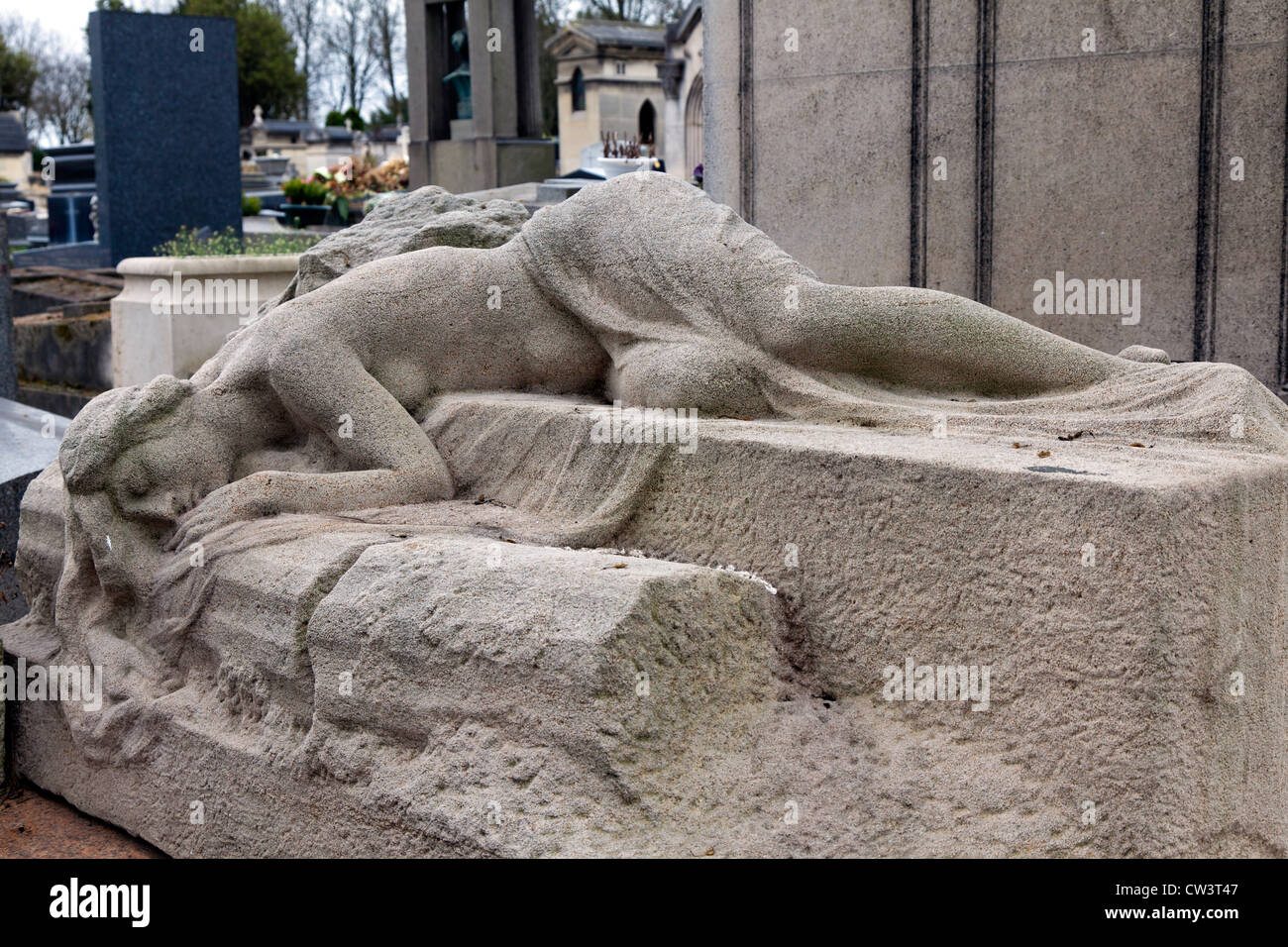 Stone sculpture of a woman lying on a grave, Pere Lachaise cemetery, Paris, France Stock Photo