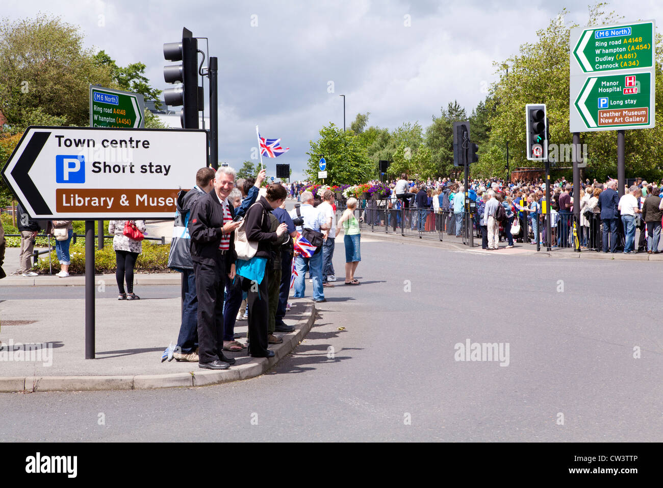 Crowds line the roads of Walsall, West Midlands to await the passing of the Olympic Torch and its bearer Stock Photo