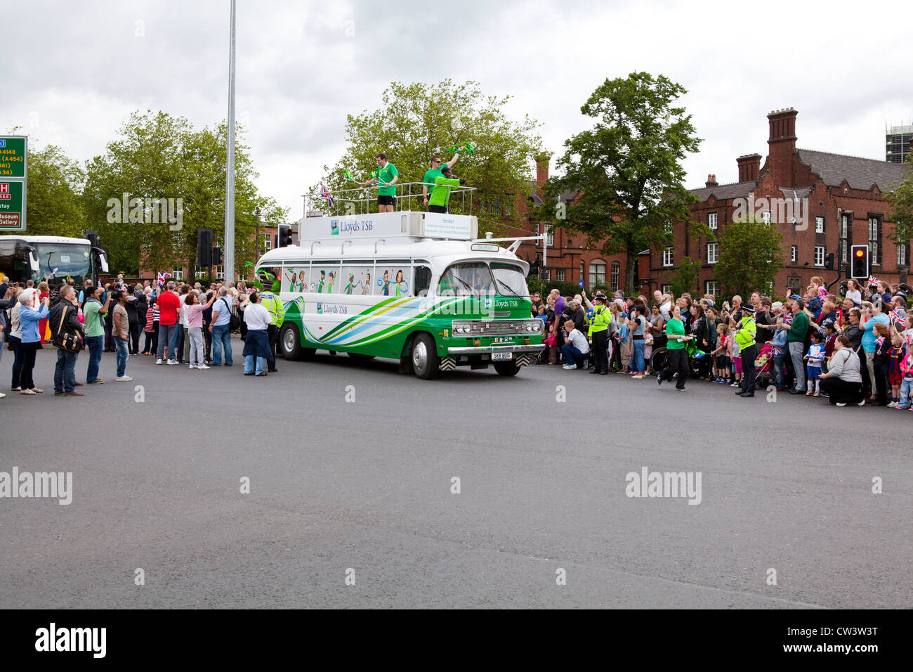 Crowds line the streets of Walsall, West Midlands to await the passing of the Olympic Torch and its bearer preceded by sponsors Stock Photo
