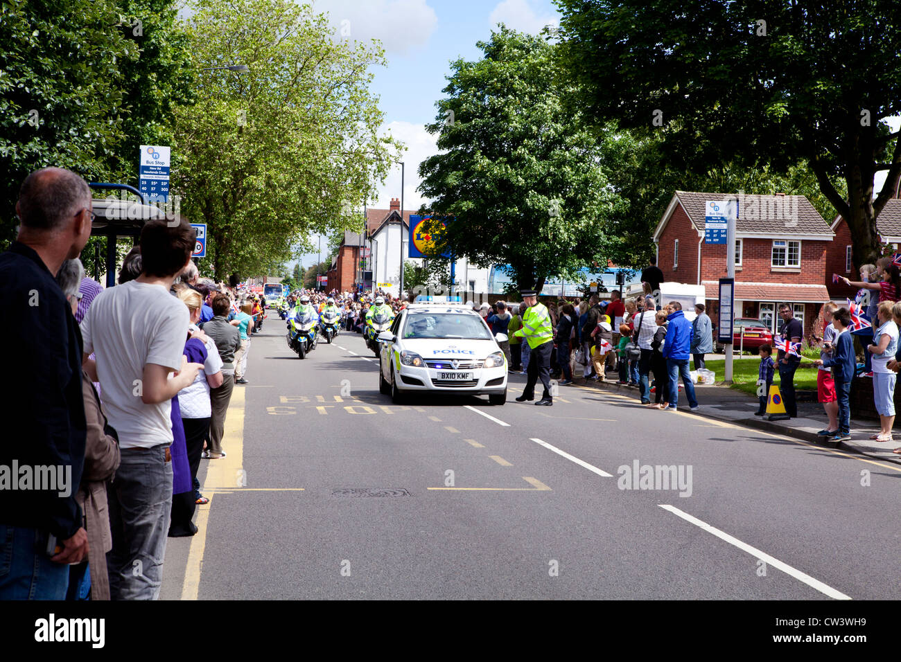 Crowds line New Road, Willenhall, West Midlands to await the passing of the Olympic Torch and