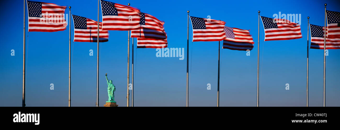 This an image Statue Liberty situated in between group American flags on flagpoles in Liberty Park New Jersey. flags are waving Stock Photo