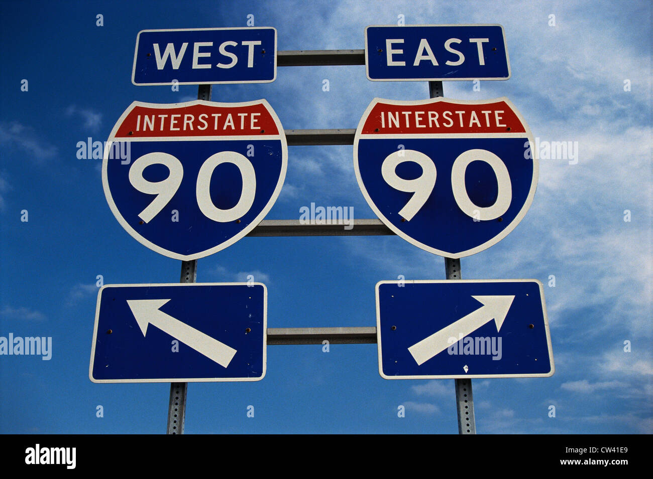 This road sign on New York State Freeway. It points out direction for Route 90 to go east or west. signs are blue red and white Stock Photo