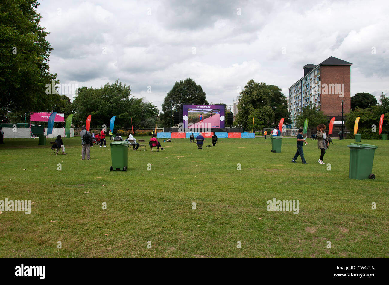 East Ham, London Borough of Newham. A few people watch the Olympics live in Central Park, Newham Stock Photo