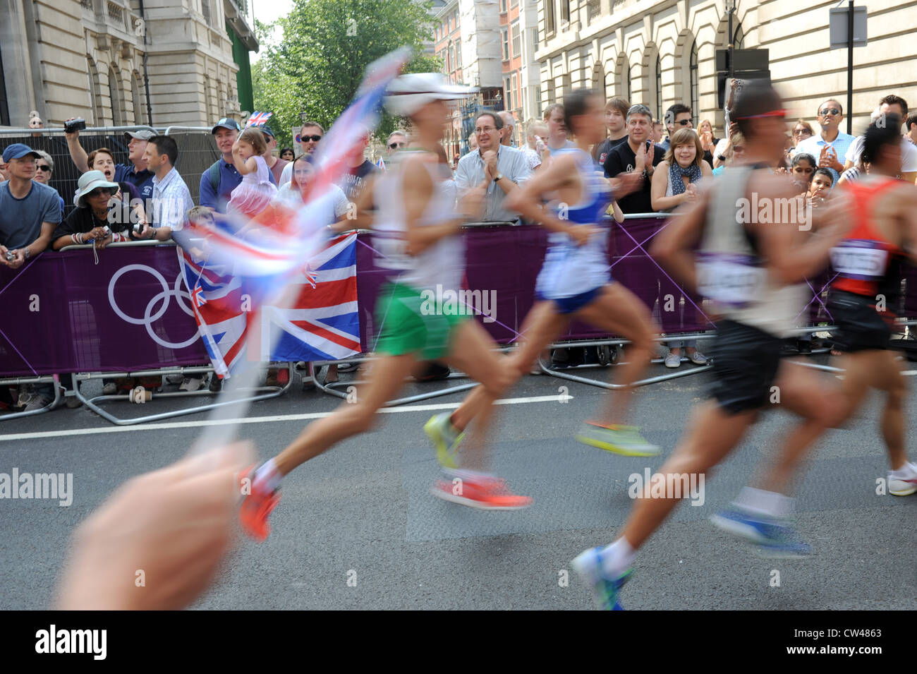 Crowds waving union jack flags during the London Olympic Marathon Mens Race 2012 UK Stock Photo