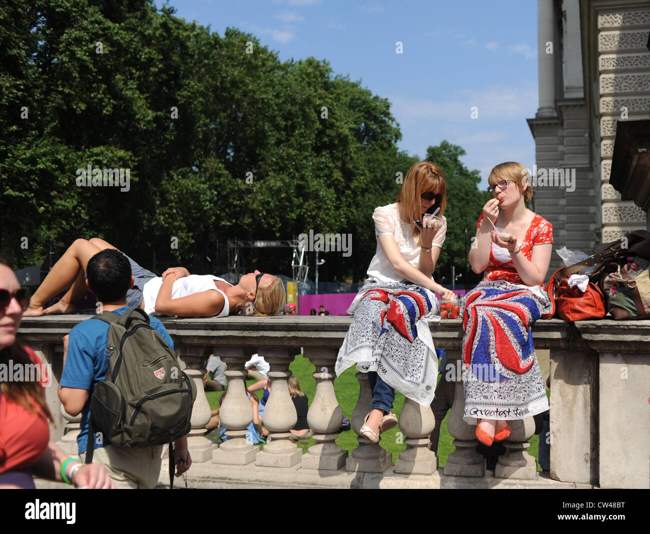 Fans eating strawberries and sunbathing at the London Olympic Marathon Mens Race 2012 UK Stock Photo