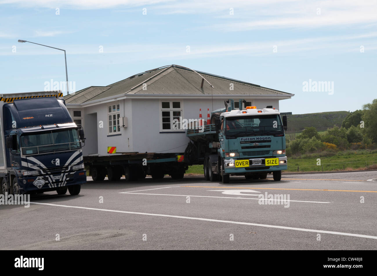 Sometimes whole houses are moving on the road through New Zealand.  Auf den Straßen Neuseelands ist ein ganzes Haus unterwegs. Stock Photo