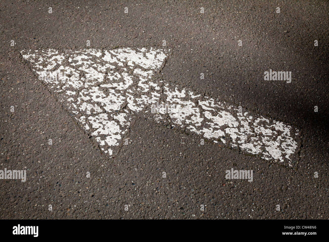 White arrow sign painted on road surface Stock Photo