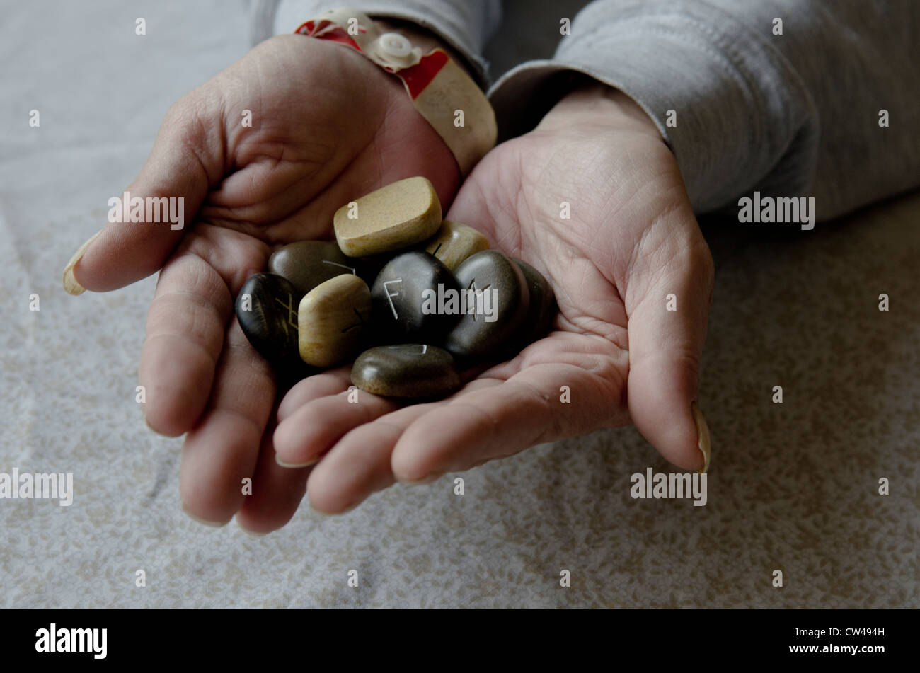 Rune stones held by a psychic during a reading Stock Photo