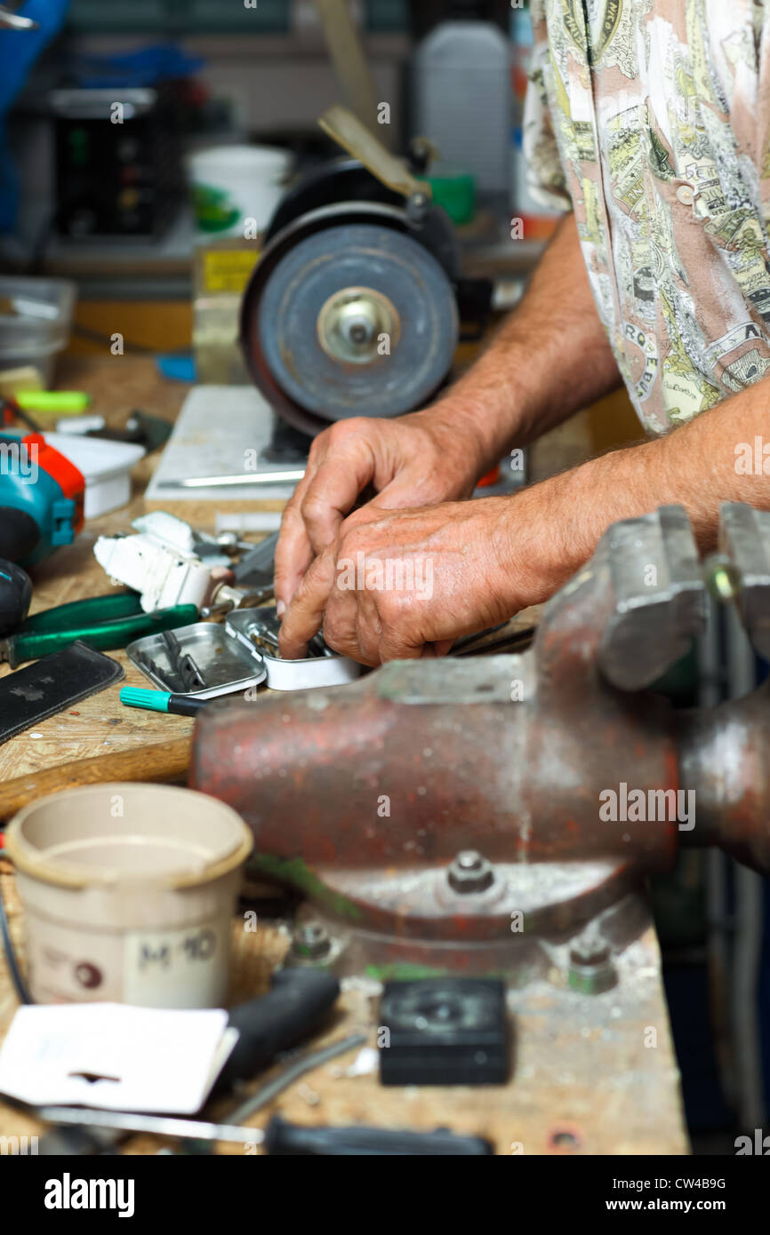 Senior working in workshop with different tools Stock Photo