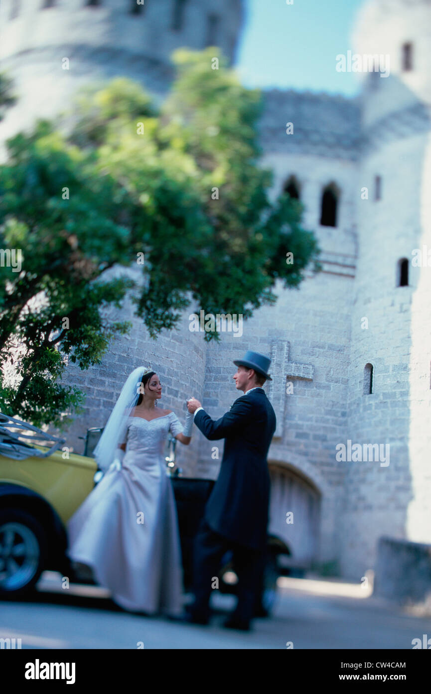 Groom helping his bride into an antique car Stock Photo - Alamy