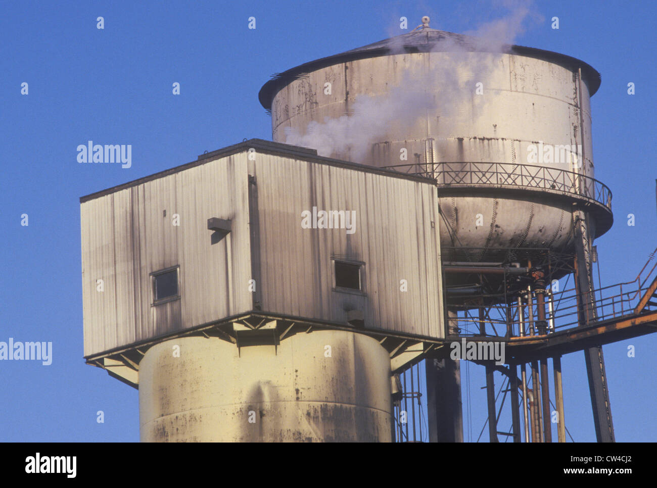 Factory smokestacks with smoke and a blue sky Stock Photo - Alamy
