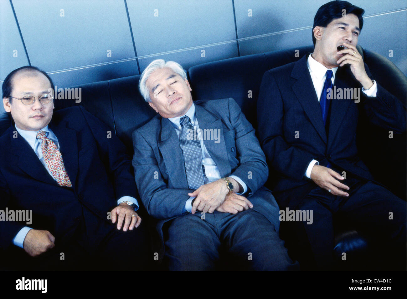 Three businessmen sitting on a couch in an office Stock Photo - Alamy