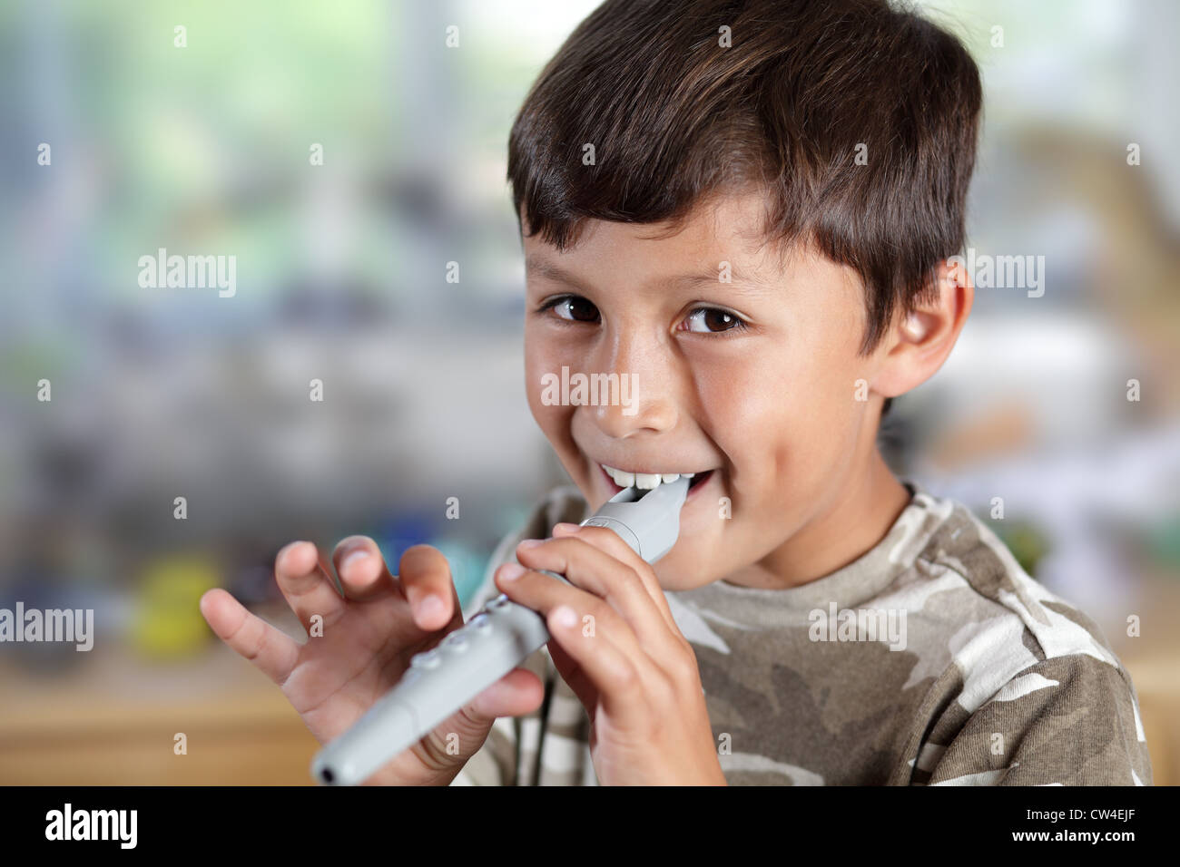A young boy plays a recorder with concentration shallow depth of