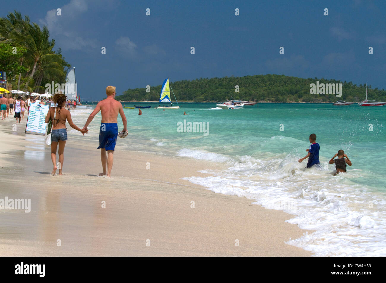 People walk hand in hand along the Gulf of Thailand at Chaweng beach on the island of Ko Samui, Thailand. Stock Photo
