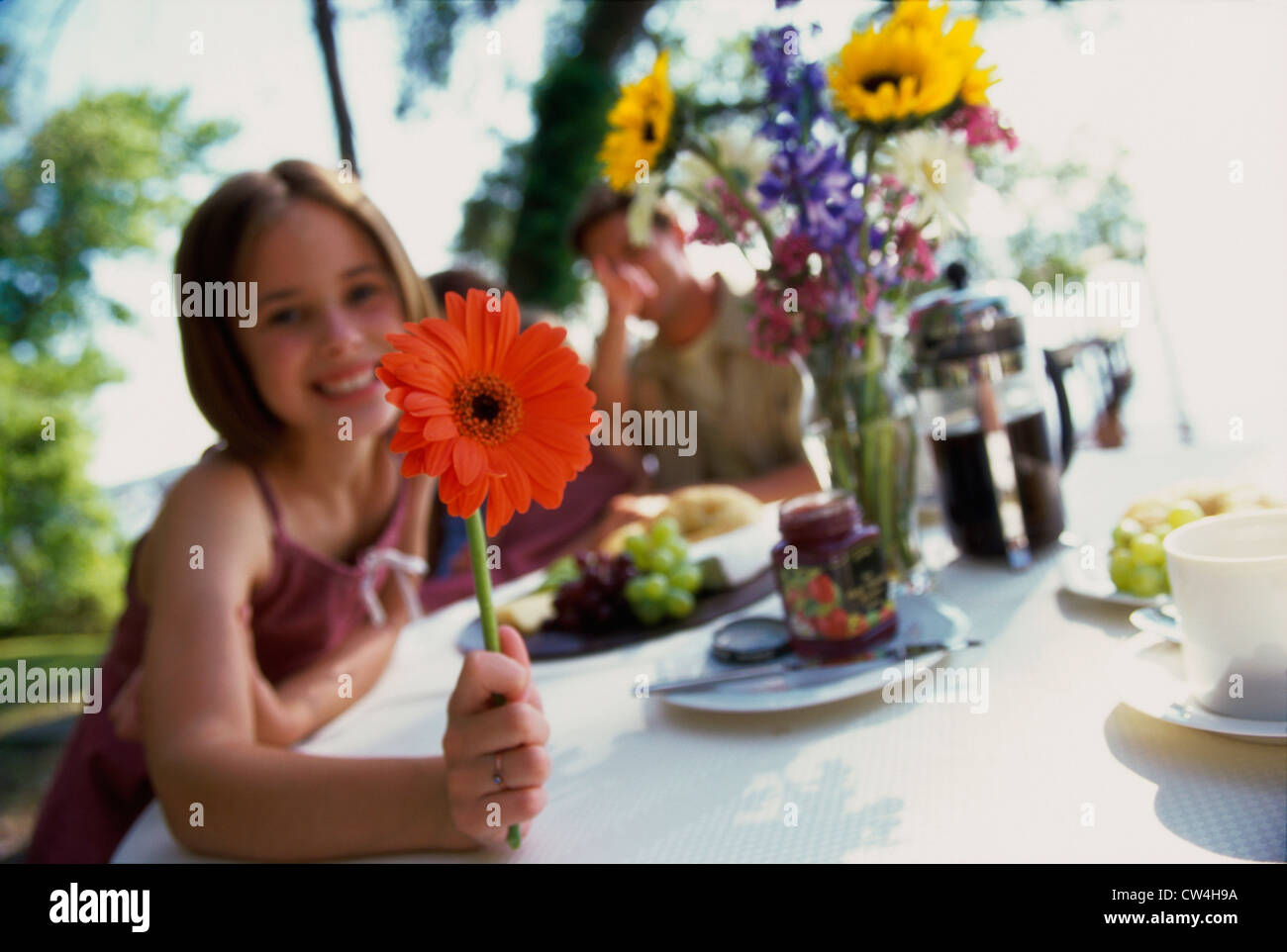 Portrait of a girl holding a flower and smiling Stock Photo - Alamy