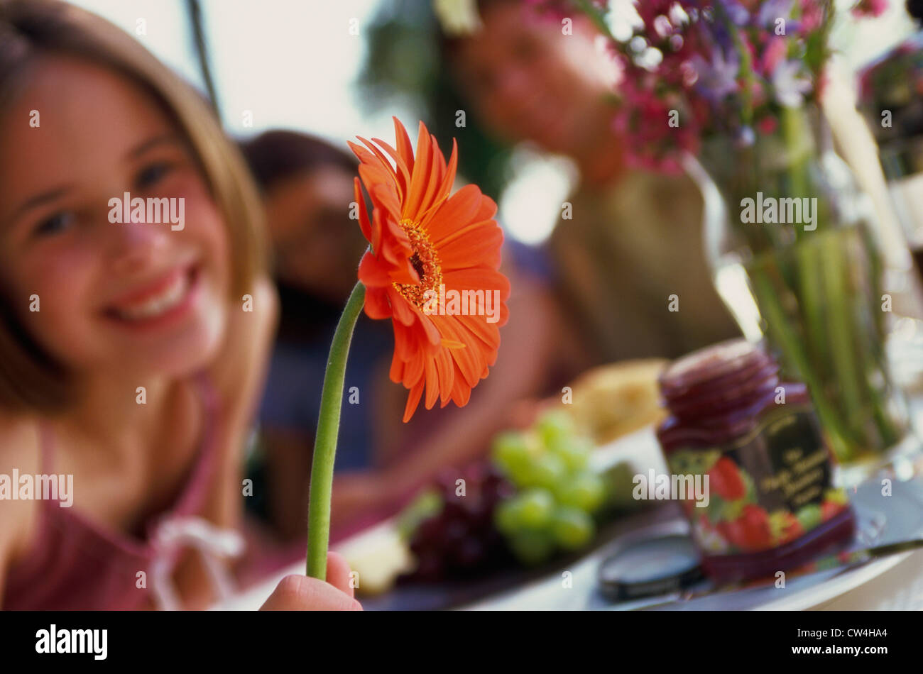 Portrait of a girl holding a flower and smiling Stock Photo - Alamy