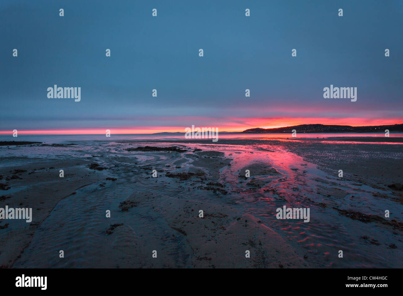 Sunrise over a beach in Wales showing red sky Stock Photo Alamy