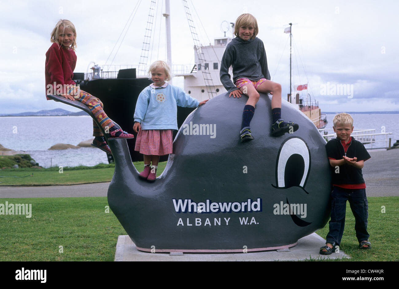 Four siblings posing on a whale statue at Whaleworld. Stock Photo