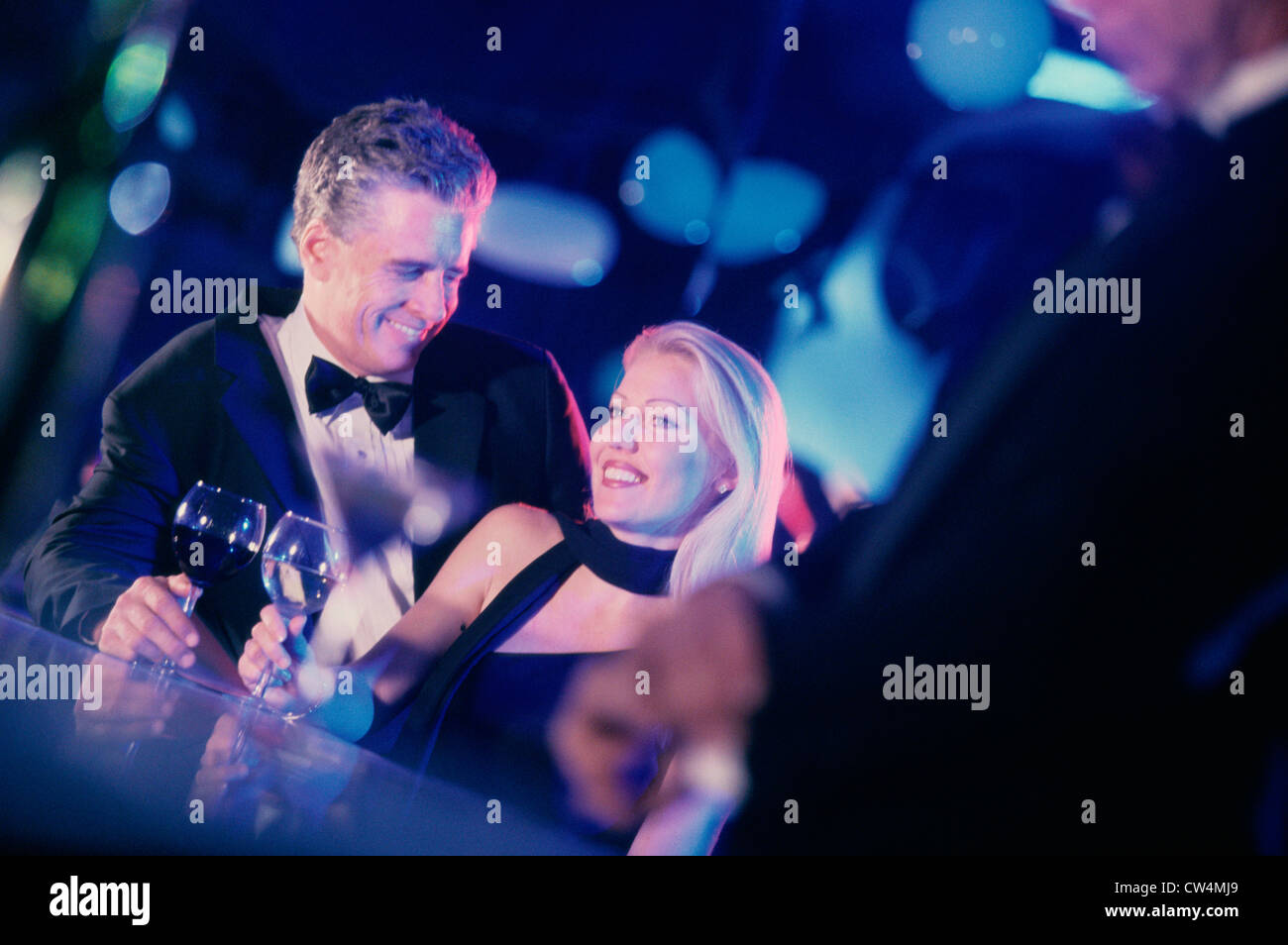 Mid adult couple holding glasses of wine in a bar and smiling Stock Photo