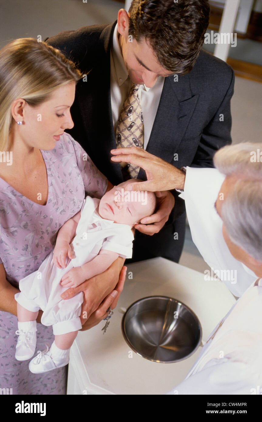 Closeup of parents with their son at a baptism Stock Photo Alamy