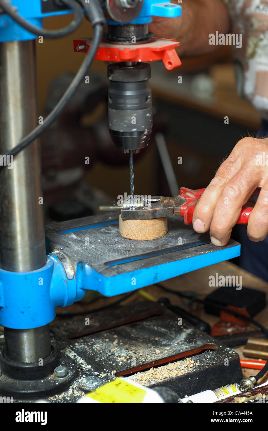 Detail of hands working on drilling machine Stock Photo