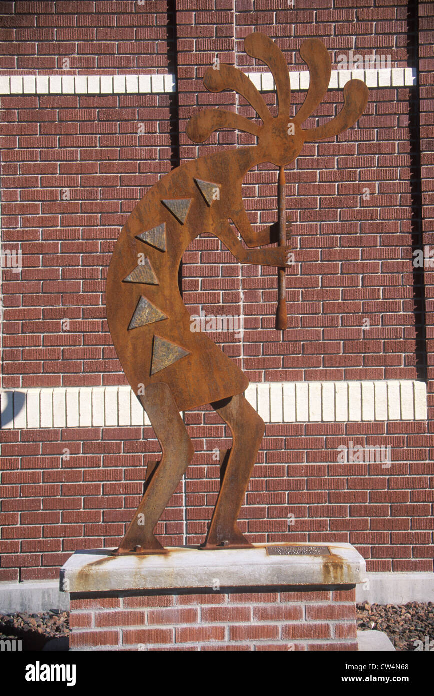 Statue of Kokopelli, Quetzal God with brick wall in background Stock
