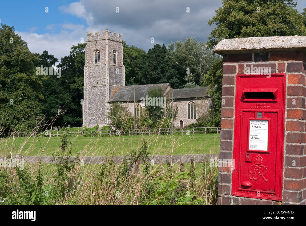 The Church of St Andrew & St Peter and Red Post Box in North Burlingham, Norfolk Stock Photo