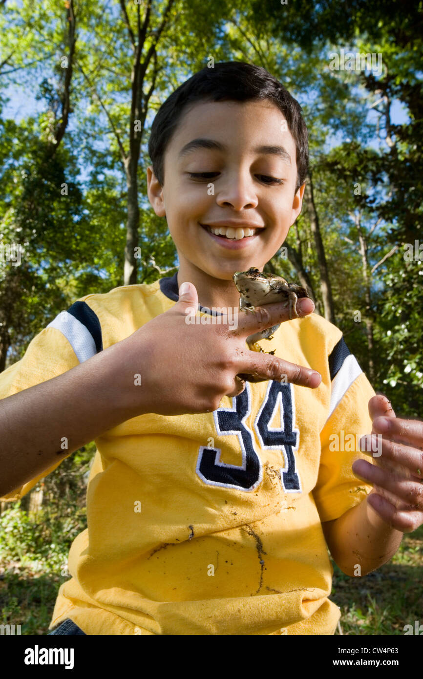 Boy holding a frog on his fingers at forest Stock Photo