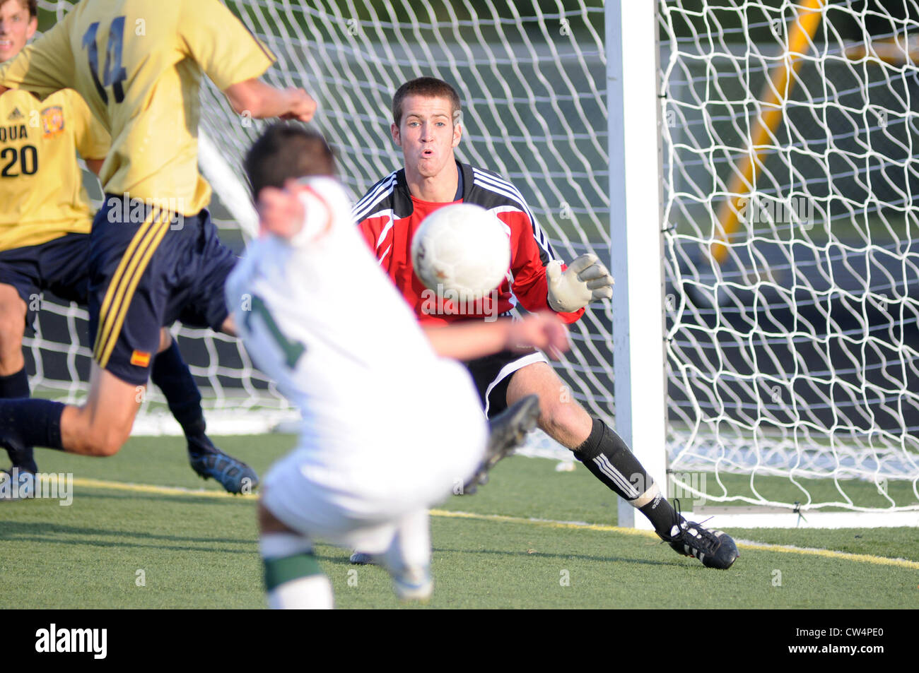 Soccer keeper highly focused on a shot from close range during a high school match. USA. Stock Photo