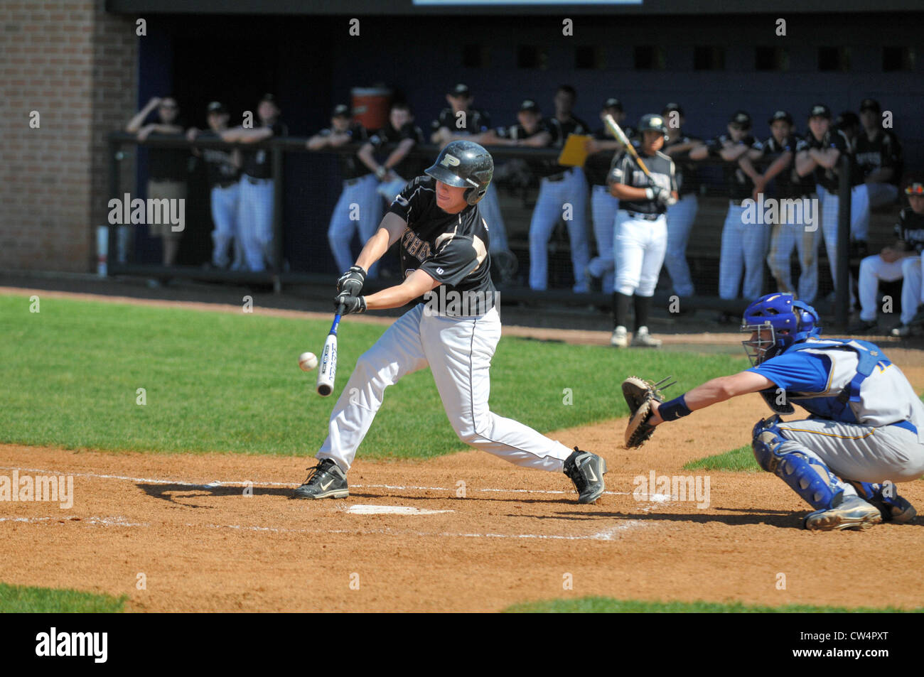 Flex is evident in an aluminum bat prior to contact by a batter during a high school game. Stock Photo