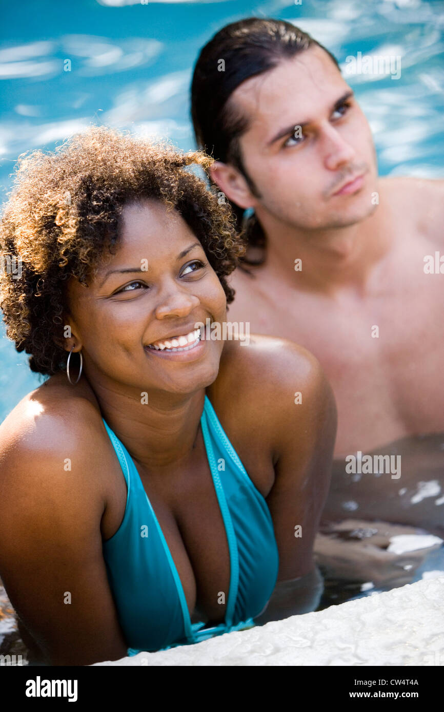 Cheerful young couple looking up in swimming pool Stock Photo