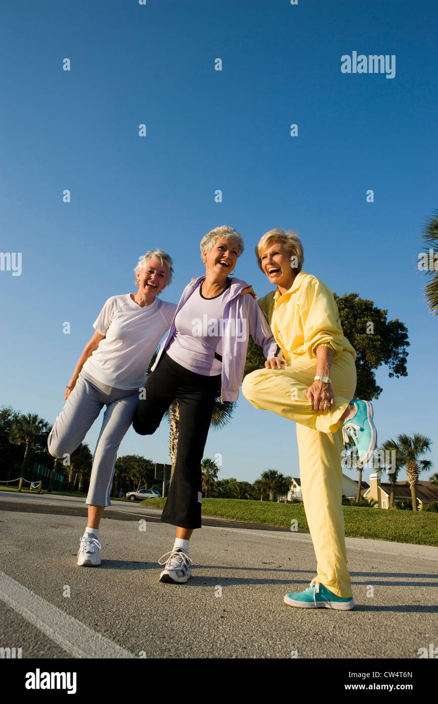 Senior women laughing while balancing on one leg Stock Photo