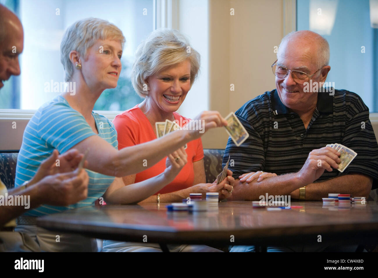 Senior men and women playing cards Stock Photo