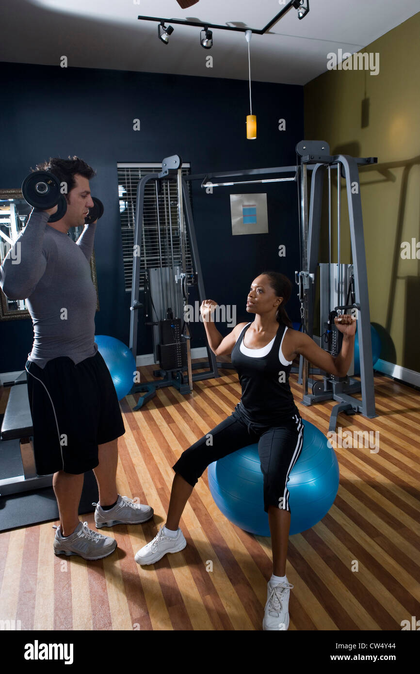 Trainer Instructing A Young Woman In The Gym Stock Photo Alamy