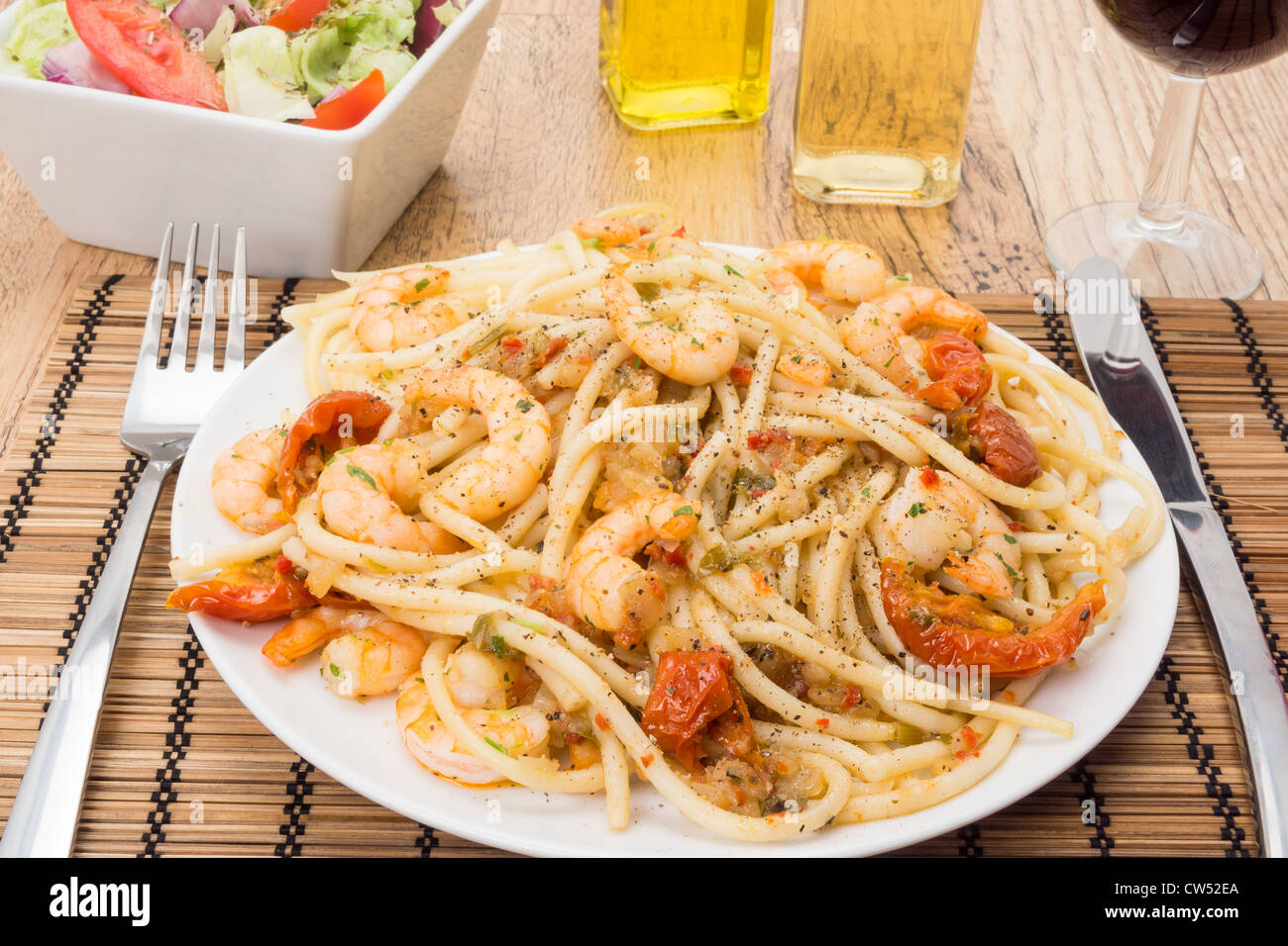 King prawns tossed through bucatini pasta and garnished with sun dried