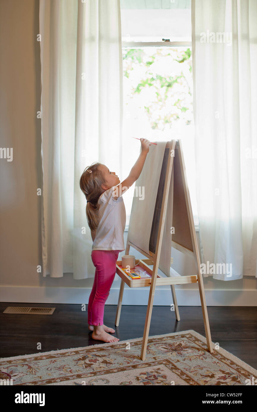 Girl painting on easel Stock Photo - Alamy