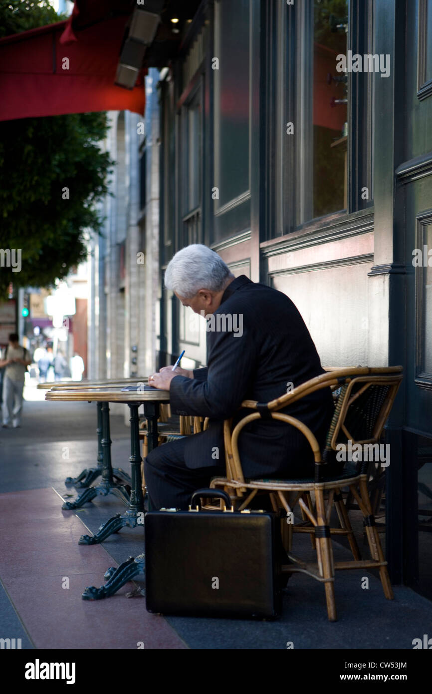 Businessman writing on a sheet of paper Stock Photo