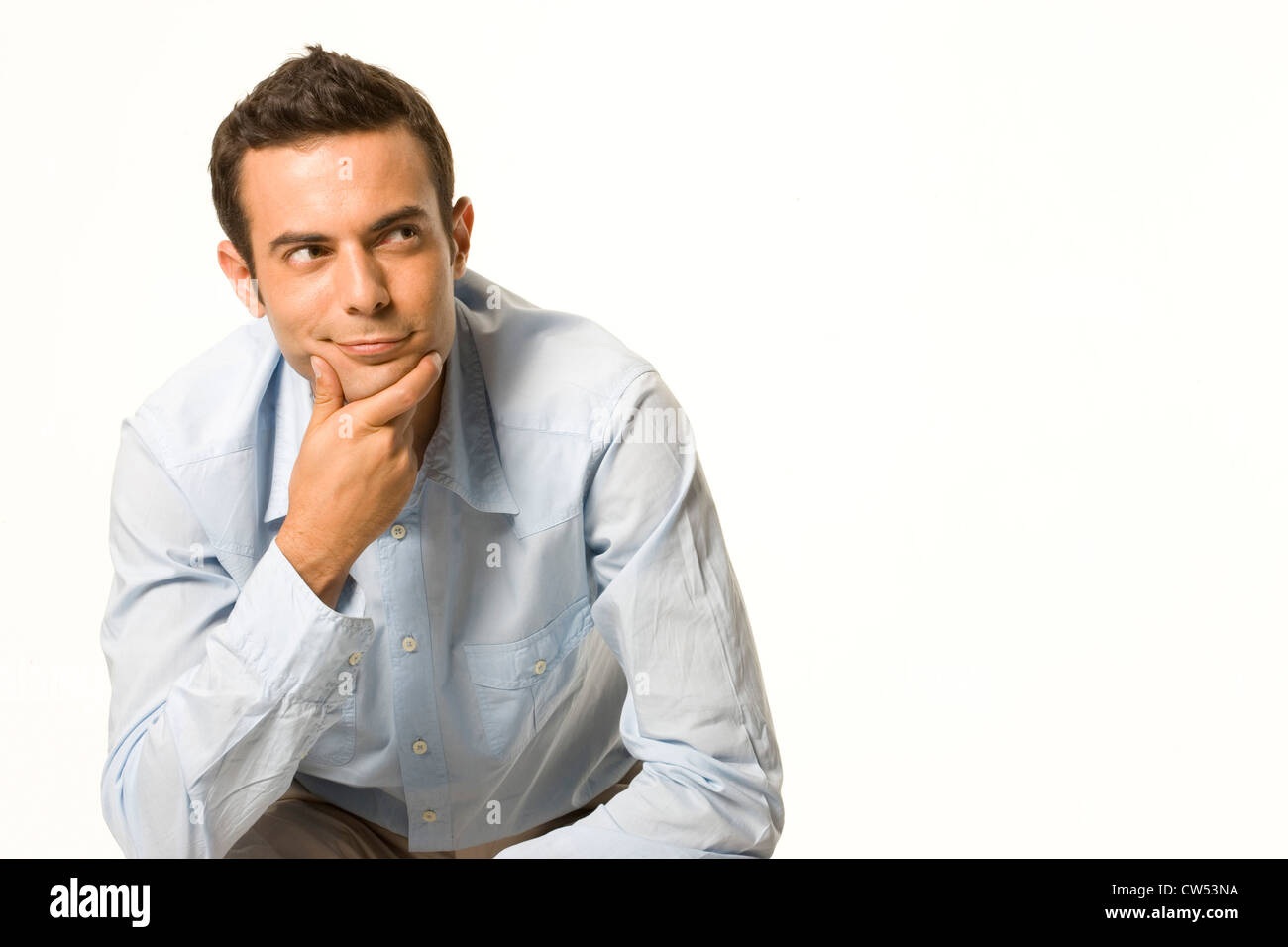 Businessman smirking with his hand on his chin Stock Photo